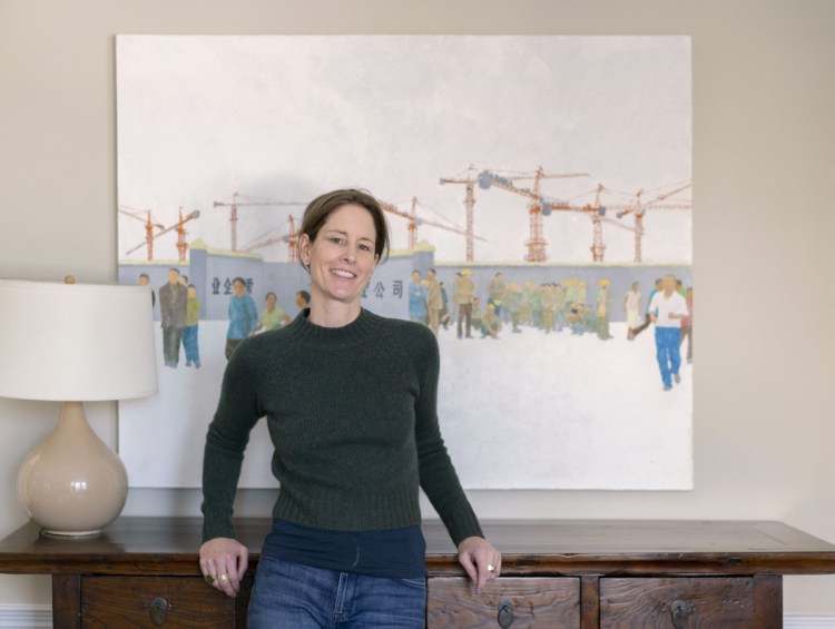 Author Susan Conley poses for a photo in her Portland home near a painting of the Beijing waterfront on Tuesday, December 18, 2018. Conley's new novel, Elsey Come Home, is set in Beijing and is getting praise and rave reviews. 