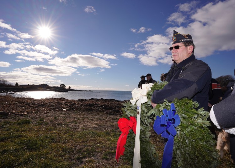 Tom Willey of the American Legion Post 159 in Kennebunkport holds a wreath during a ceremony honoring George H.W. Bush across from Walker’s Point in Kennebunkport on Tuesday.
