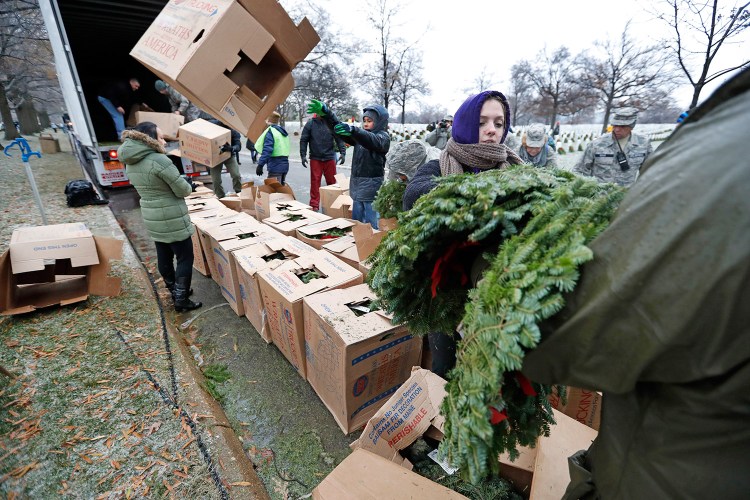 Wreaths Across America volunteer Alyssa Kane of Alexandria, Virginia, helps unload and distribute wreaths to be placed at Arlington gravesites in December 2016. 