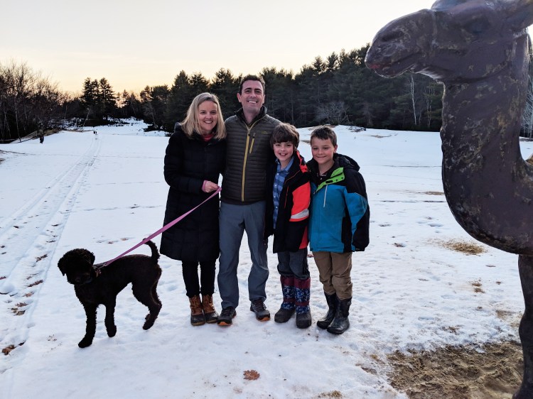 Mela and Doug Heestand, new owners of the Desert of Maine, pose near the attraction's camel statue with their sons Nicky, right, and William, and their dog Autumn.