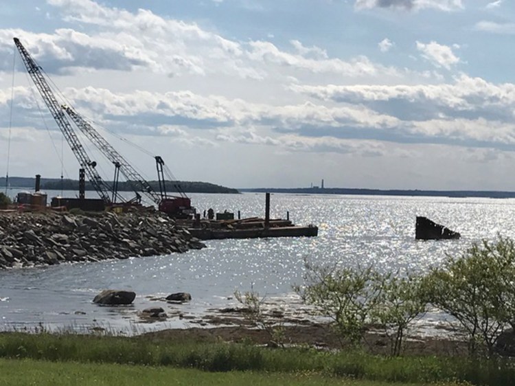 Workers from Reed & Reed remove the old pier off Mitchell Field in June.