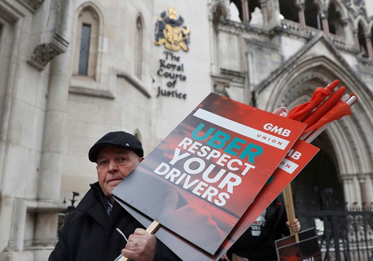 A member of the GMB union holds onto placards as he takes part in a GIG economy workers protest outside the Royal Courts of Justice ahead of a legal hearing over employment rights in London in October.