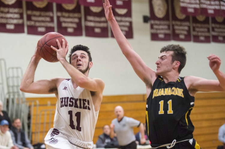 Maine Central Institute's Gavin McCarthur (11) drives to the basket as Maranacook's Garrett Whitten, right, tries to defend Wednesday in Pittsfield.