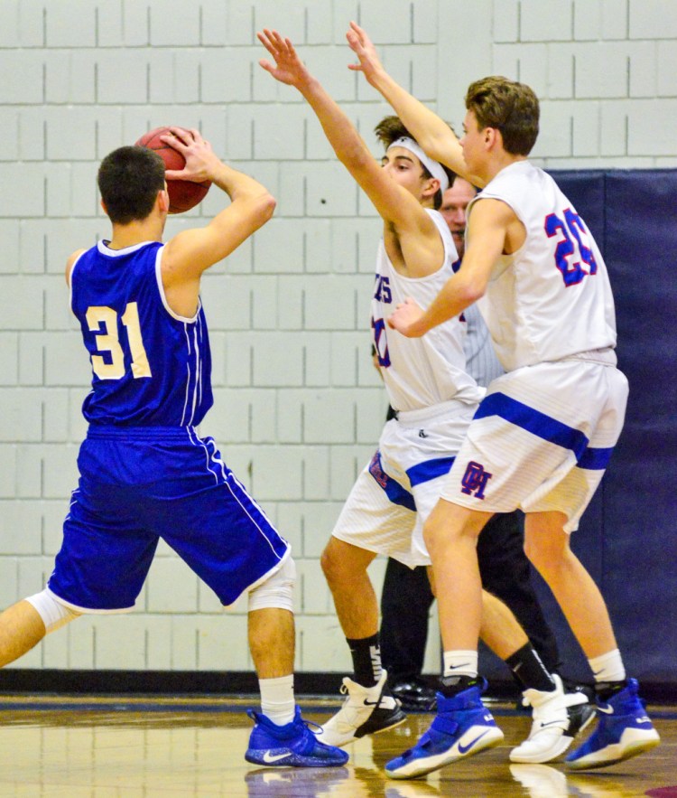 Madison's Eric Wescott, left, is defended by Oak Hill's  Gabe Samson and Isiah Morgan (25) during a Mountain Valley Conference game Thursday in Wales.