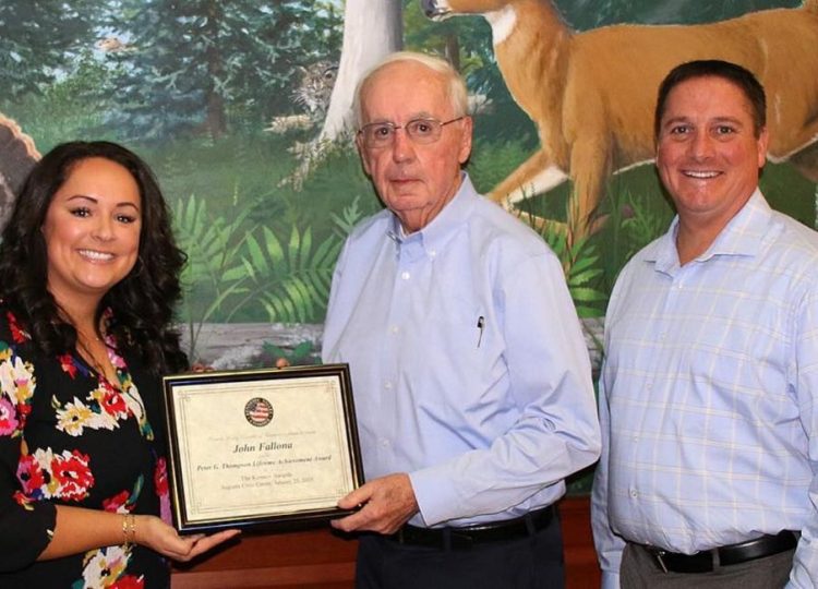 Katie Doherty, president and CEO of the Kennebec Valley Chamber of Commerce, left, and Eric Jermyn, a member of the chamber's board of directors, right, present the Peter G. Thompson Lifetime Achievement Award recently to John Fallona.