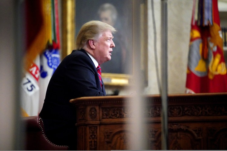 As seen from a window outside the Oval Office, President Donald Trump gives a prime-time address about border security Tuesday at the White House in Washington.