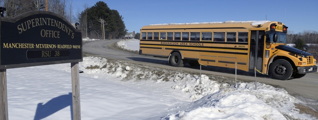 A bus exits Millard Harrison Drive, the access road to Maranacook Community High School. Maranacook Community Middle School and the superintendent's office, on Monday in Readfield. Regional School Unit 38's voters have approved a plan to repave the road, among several facility projects.