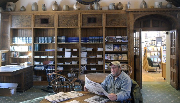 George Tatsak reads the newspaper Monday at the Gardiner Public Library. Gardiner officials proposed a new library fee schedule for partner communities based on the number of residents in each town. This comes after several years of concern by partner towns that the fees were too high and not predictable.