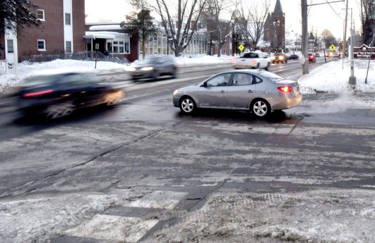 Traffic passes at the busy intersection and crosswalk at Main and South streets in Farmington near the University of Maine campus properties on Monday.