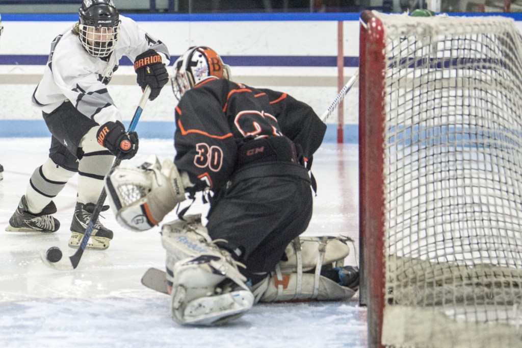 Kennebec's Tommy Tibbetts, left, puts a shot on Brewer goalie Tyler St. Lawrence in the second period last month at Colby College in Waterville.