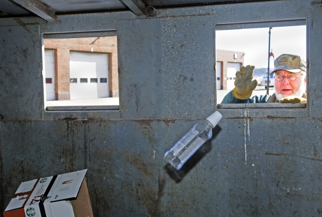 Davy Crockett tosses recyclables into a city container in 2015 at the John Charest Public Works Facility in Augusta.
