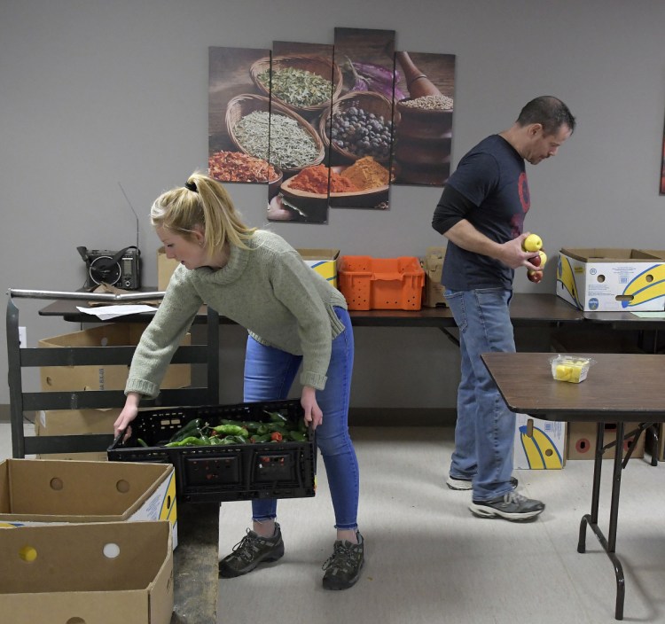 Augusta Food Bank staff members Melissa Shea and Andy Waller collect items for customers Tuesday. Several food security groups in central Maine have opened their doors to federal employees who have gone unpaid since December.