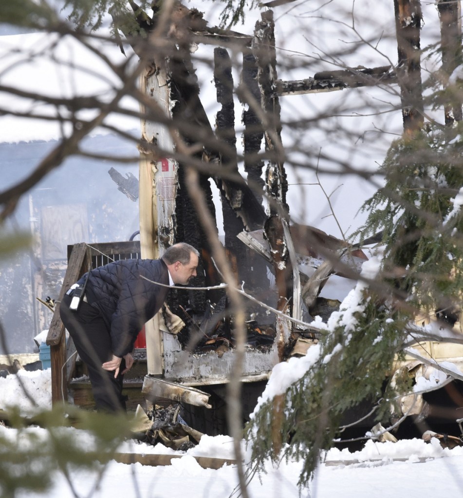 Skowhegan Fire Chief Shawn Howard inspects the scene of a fire as firefighters from Norridgewock and Skowhegan put out the fire that destroyed a mobile home on U.S. Route 2 in Norridgewock on Wednesday.