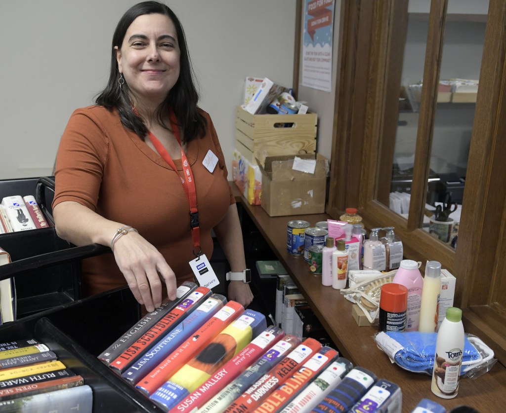 Lithgow Public Library Director Sarah Schultz-Nielsen with books and donated staples such as toiletries on Wednesday in Augusta. The library is running a fine forgiveness program through the end of January permitting cardholders to donate nonperishable food and essential items in exchange for having their overdue fines forgiven.