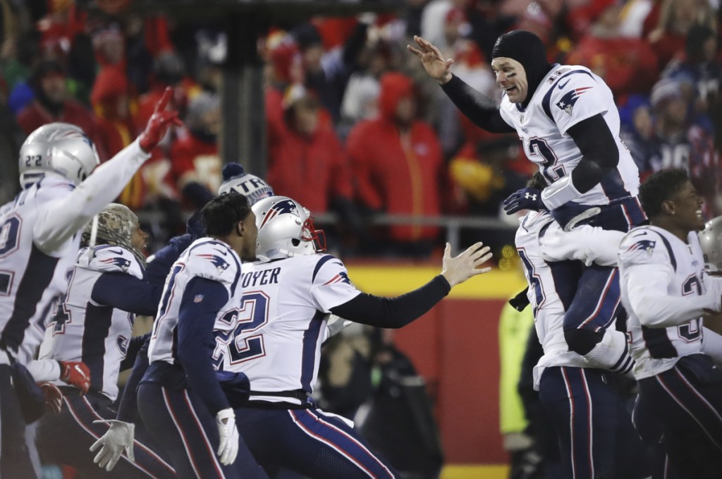 New England Patriots quarterback Tom Brady (12) celebrates with his teammates after they won the AFC  championship Sunday in Kansas City.