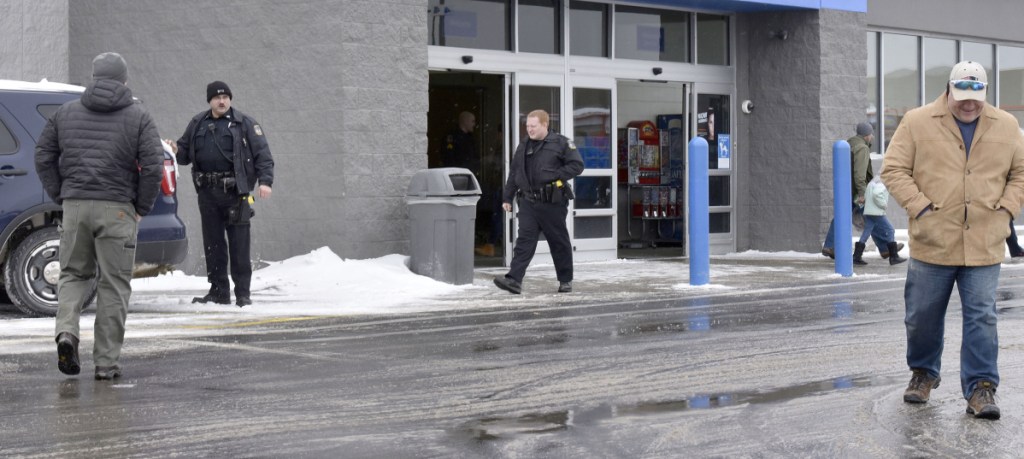 Waterville police officers Steve Brame, left, and Robert Bouley exit the Waterville Walmart along with customers after police were called to the store after a man was spotted with a handgun inside the store on Monday.