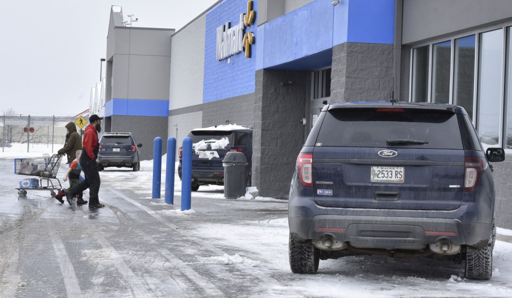 Customers at the Waterville Walmart store walk past three Waterville police cruisers while officers were inside the store investigating a report of a man with a handgun on Monday.