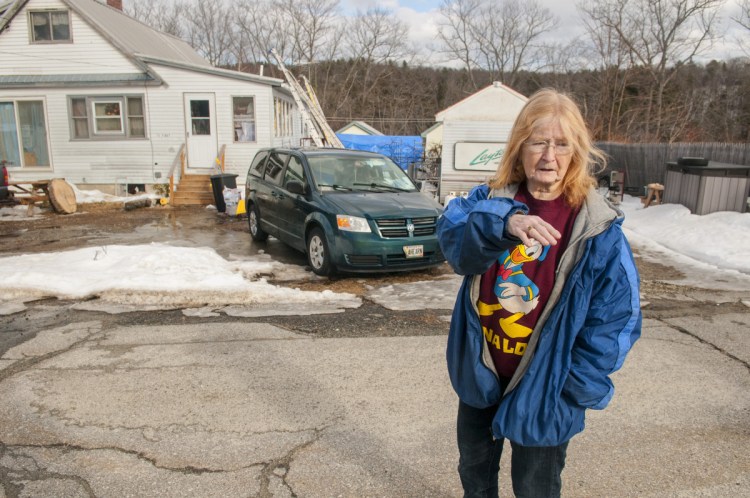 Merleen Ahearn talks about drainage problems Friday in front of her home on Clark Street Extension in Farmingdale.