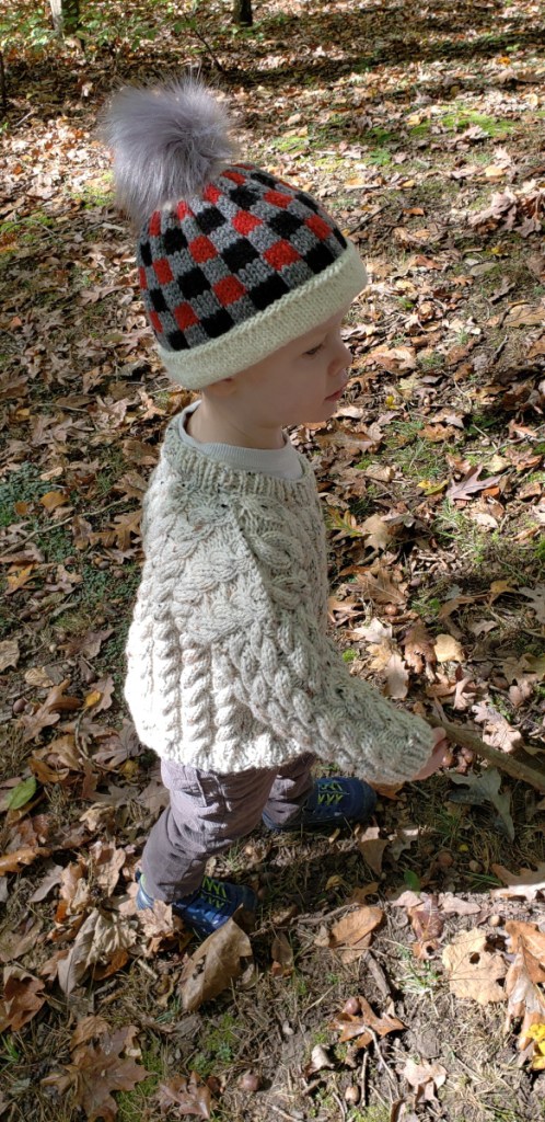 A child sports some of Outdoor Babies' hand-knit clothing.