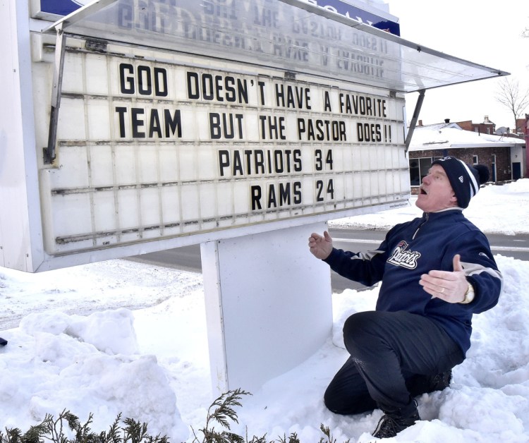 New England Patriots fan the Rev. Mark Tanner makes his Super Bowl prediction known publicly Thursday outside the Federated Church in Skowhegan by posting a notice that the Patriots will beat the L.A. Rams, 34-24.