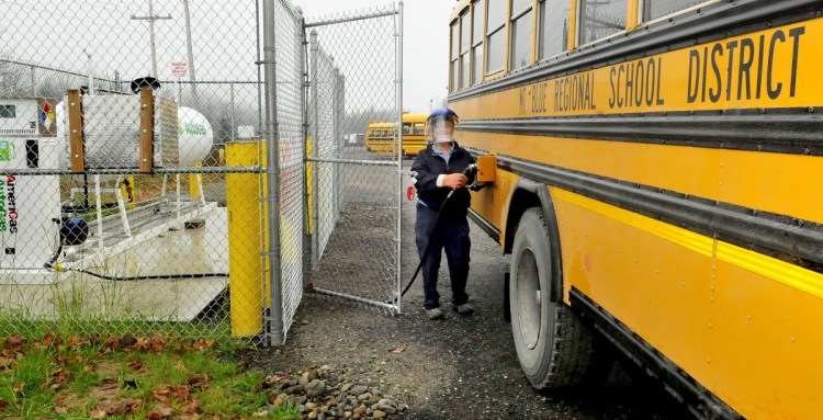 Regional School Unit 9 bus driver Nancy Richardson dons protective gear while filling one of four new buses with propane rather than diesel on Oct. 29, 2014. A threat claiming a bomb was on a bus was called into RSU 9 at around 3:30 p.m. Thursday. Authorities were dropping school children off at fire stations and searching the buses into the evening.