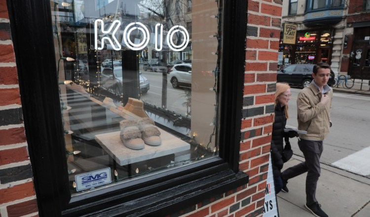Pedestrians pass by the Koio shop, which sells Italian sneakers, on west Armitage Avenue in Chicago. Some online retailers are finding many of their customers also like a traditional shopping environment.