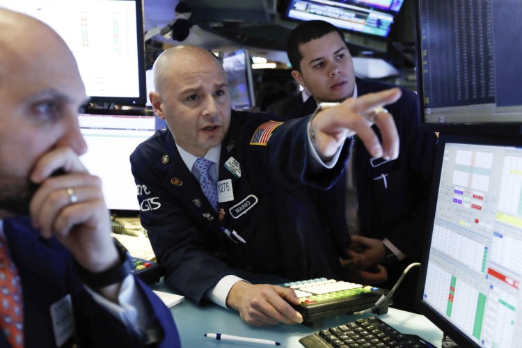 Mario Picone, center, works with fellow specialists on the floor of the New York Stock Exchange on Friday. Investors welcomed news of trade talks between the U.S. and China and a big gain in jobs in the U.S.