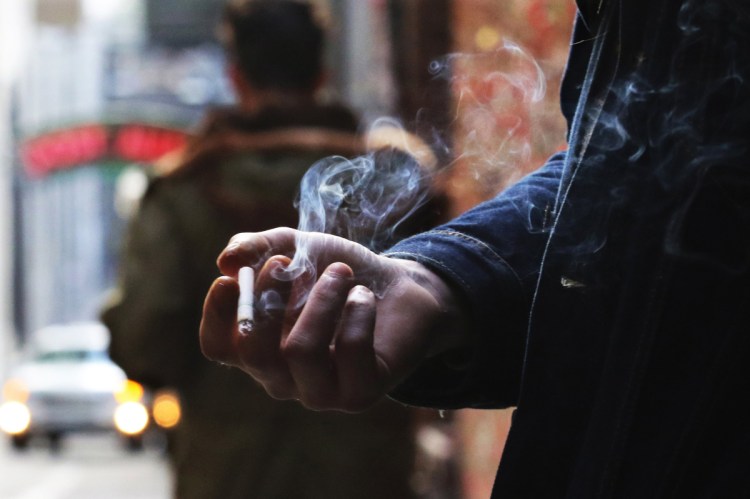 Leyland Foster has a cigarette break in Post Alley, smoking a Camel Crush with a capsule in the filter that, when squeezed, releases menthol flavor. He's been smoking since he was 16, about 14 years. "With coffee, oh yeah." (Alan Berner/Seattle Times/TNS)