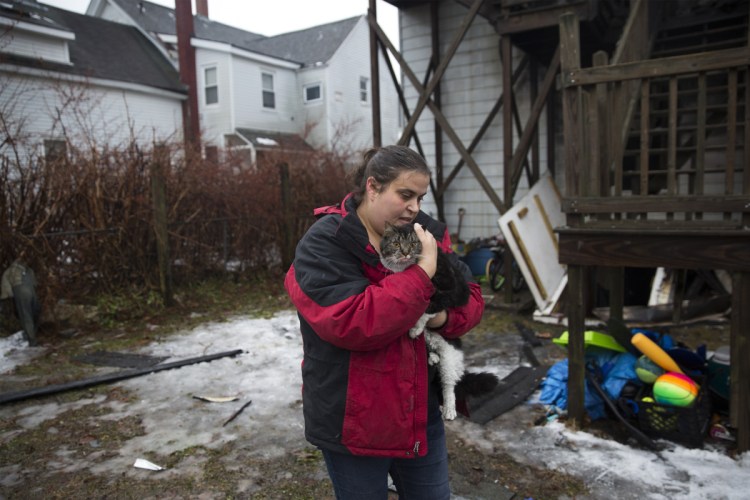 Jolean Beane carries her sister-in-law's cat Jax back to her car after she caught him outside of the apartment building that caught fire on Swett Street in the early morning on Wednesday, January 9, 2019. Bean said her sister-in-law's family escaped the fire and left the backdoor open as they left. They didn't know what happened to their cat Jax. Beane spent the morning looking for him and finally found him as he ran back to his home. "We didn't think there was any way the cat got out," Beane said. "The kids will be so happy."