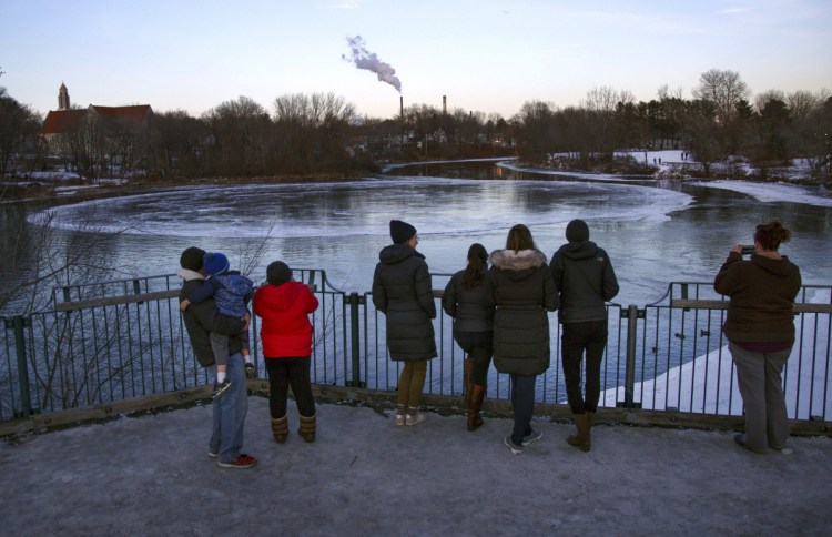 People gather to watch the ice disk on Jan. 17. The natural phenomenon has been a boon for businesses in Westbrook, where one bar has named a cocktail the "Ice Disk Cosmo."