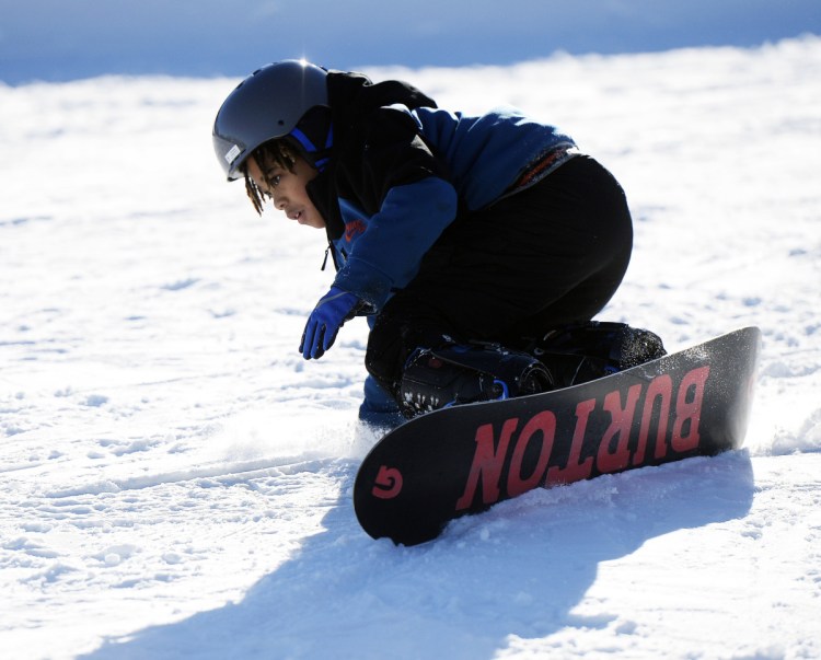 Nehemiah Suneus, 10, of the Boys & Girls Club of Dorchester, Mass., concentrates as he learns to snowboard at Shawnee Peak last weekend. Suneus was snowboarding for the first time and picked it up in 10 minutes.