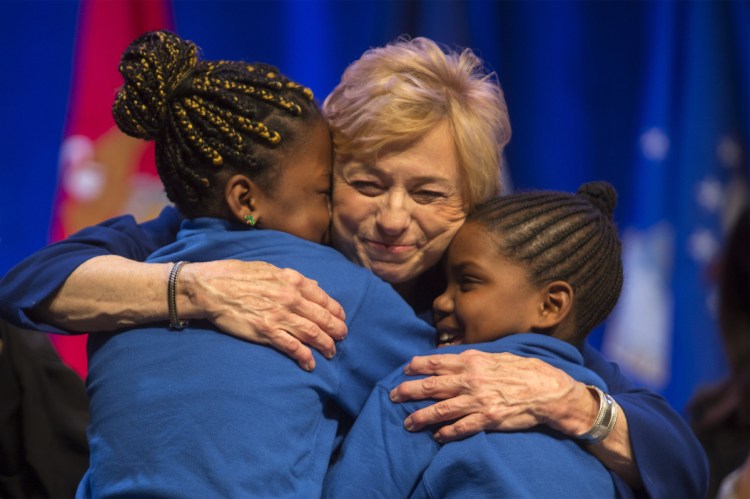 Gov. Janet Mills hugs Natalia Mbadu, 10, and Shy Paca, 11, after they sang a rendition of the song "Girl on Fire" during her inauguration ceremony at the Augusta Civic Center on Jan. 2.