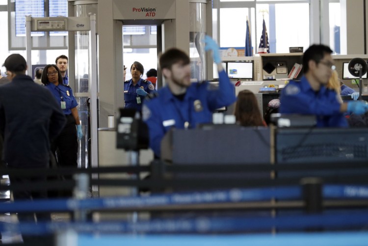 Transportation Security Administration officers work at a checkpoint at O'Hare airport in Chicago. The TSA said Sunday's absence rate of 10 percent compared to 3.1 percent on the same Sunday a year ago.