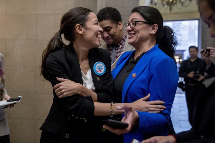Rep. Alexandria Ocasio-Cortez, D-N.Y., left, and Rep. Rashida Tlaib, D-Mich., laugh as they wait for other freshman congressmen to deliver a letter calling for an end to the government shutdown on Jan. 16.
