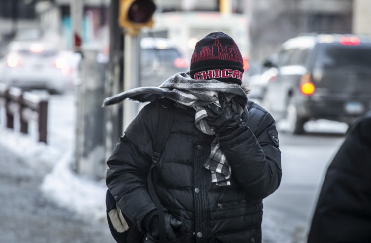 A commuter heads for work early Wednesday in brutally cold Chicago. Meanwhile, Australia is experiencing all-time record heat. It's important to take the whole Earth into account – not just one area, experts say.