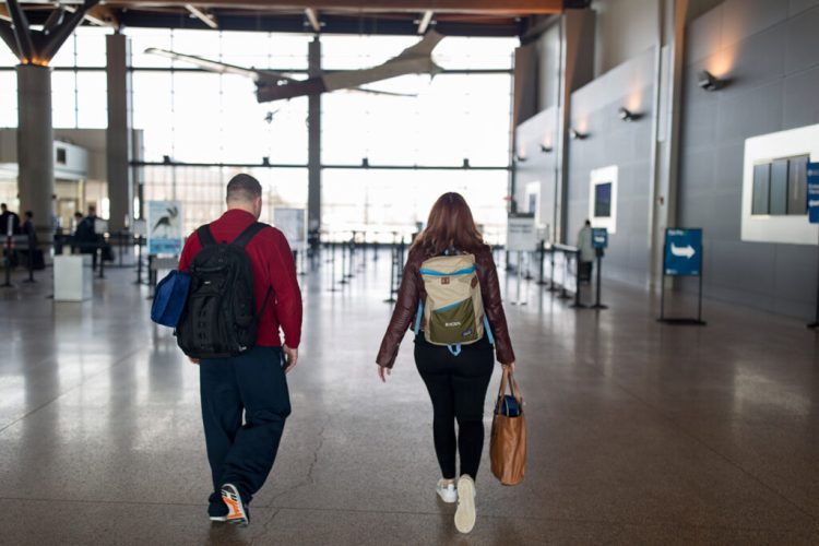 Kyle Benson, of Westbrook, left, and Mo Placey, of Gorham, walk to security for their flight to Phoenix at the Portland Jetport on Friday, January 25, 2019. LaGuardia in New York City that experienced delays Friday due to staffing issues because of the government shutdown. Placey and Benson said they hadn't heard any news about delays on their flights. "Fingers crossed," Placey said. 