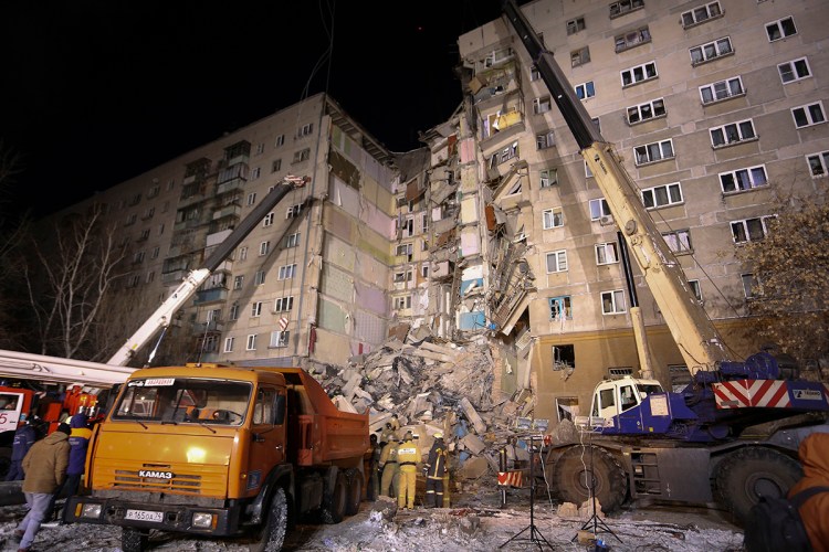 Emergency Situations employees working at the scene of a collapsed apartment building in Magnitogorsk, a city of 400,000 people, about 1,400 kilometers (870 miles) southeast of Moscow, Russia, Monday, Dec. 31, 2018. At least four people died Monday when part of a 10-story apartment building collapsed in Russia's Ural Mountains region, and hundreds of rescuers searched for survivors under the rubble in the frigid weather. 