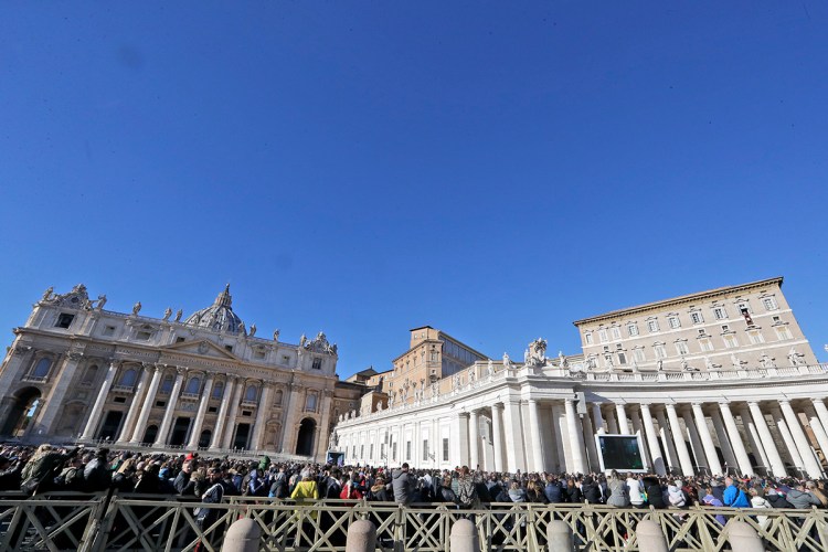 People gather in St. Peter's Square to attend a blessing by Pope Francis during the Angelus noon prayer he recited from the window of his studio at the Vatican on Tuesday.