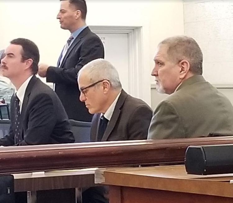 James Sweeney, 58, formerly of Jay, listens to closing arguments Monday during his murder trial in Franklin County Superior Court. His lawyers, seated from left, are Thomas J. Carey and Walter Hanstein. Standing behind them is Detective Michael Chavez of the Maine State Police.
