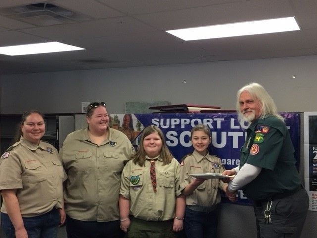 Six girls are joining Pine Tree Council's First Scouts BSA Troop from Lewiston, Troop 2019. Charters for new Scout BSA Troops officially launch Friday. From left: Scoutmaster Casey Arsenault; Stephanie Gabriel, committee chairwoman; and Emillie Gabriel and Hannah Arsenault, presenting their troop charter to Abnaki District Executive Jack Waite.