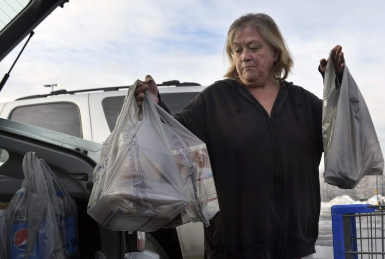 Earlinda Nirza, of Augusta, gathers plastic bags full of groceries Jan. 10 after shopping at Walmart in Augusta.