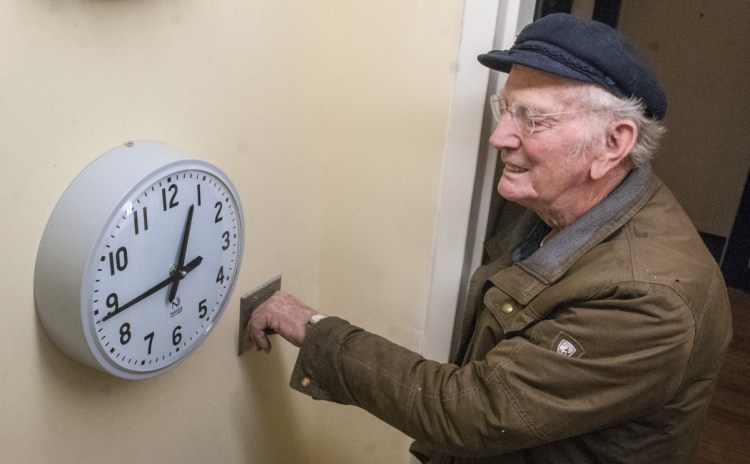 Jim Bryant waits until a pilot clock reaches 12:45 p.m. to flip a switch to turn on the tower clock Thursday at the Cony Flatiron Senior Residence in Augusta.