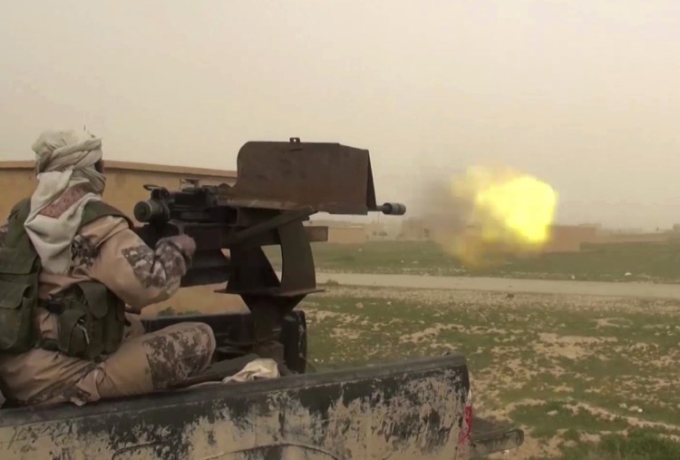 This frame grab from video posted online by supporters of the Islamic State purports to show a gun-mounted IS vehicle firing at members of the U.S.-backed Syrian Democratic Forces in the eastern province of Deir el-Zour in Syria.