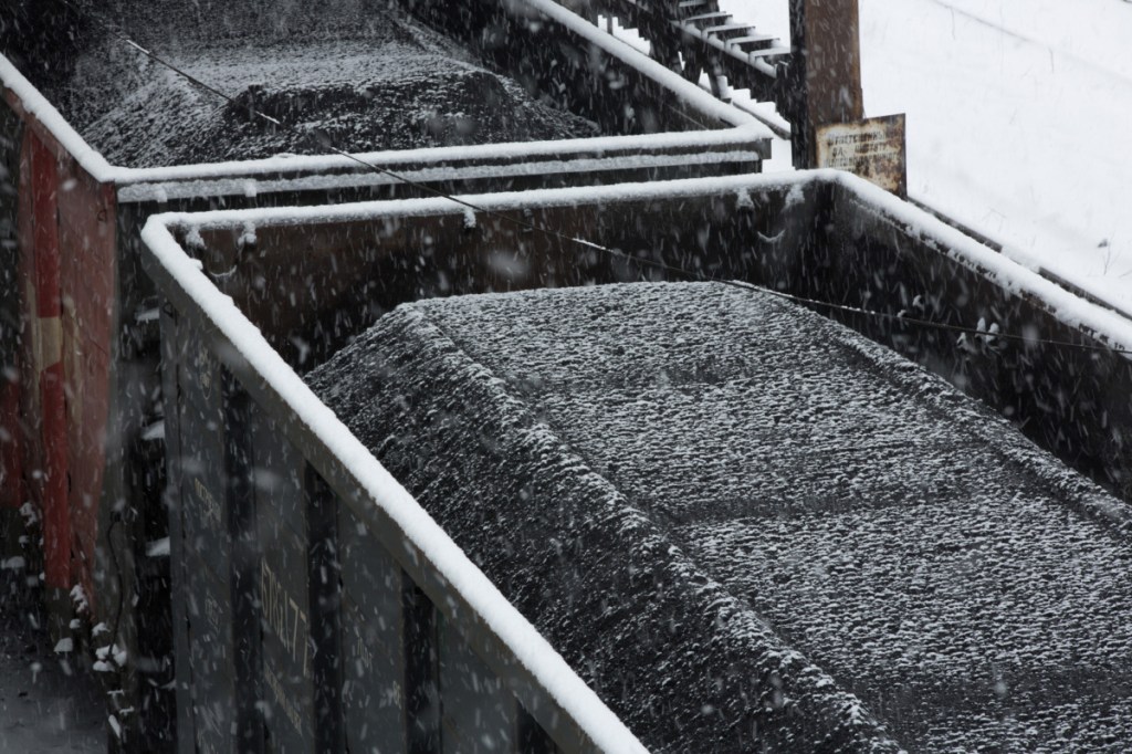 Snow falls on coal sitting in a freight wagon ahead of shipping at the dressing mill at the Sibir coal processing plant operated by OAO Mechel Mining, a unit of OAO Mechel, near Myski, Kemerovo region, Russia. MUST CREDIT: Bloomberg photo by Andrey Rudakov