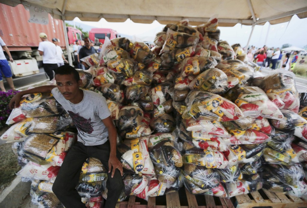 A volunteer takes a break during the distribution of bags with food subsidized by Nicolas Maduro's government near the international bridge of Tienditas on the outskirts of Urena, Venezuela.