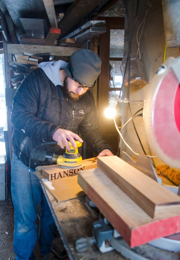 In his unheated woodshed, William Terry sands a cribbage board after drilling its holes Feb. 2 in Richmond.