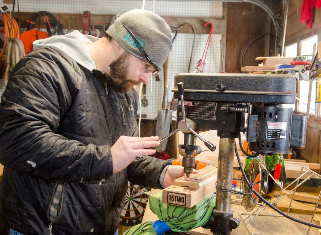 William Terry uses a drill press to drill holes into a cribbage board that he's making Feb. 2 in Richmond. He uses an old cribbage board as a guide.