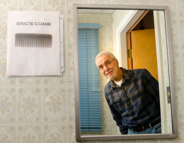 Eric Anderson poses for a portrait on Tuesday at the Farmingdale town office. The comb was hung up by town office staffers as a joke for Anderson who, until he recently retired, was U.S. Postal Service letter carrier for the office.