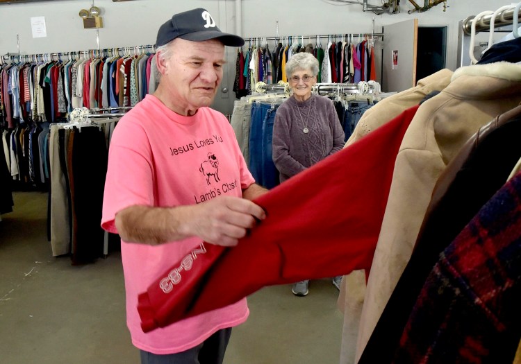 Volunteer David Scribner straightens clothing as Director Erma Blakney watches at the Lamb's Clothes Closet at the First Baptist Church in Fairfield on Tuesday.