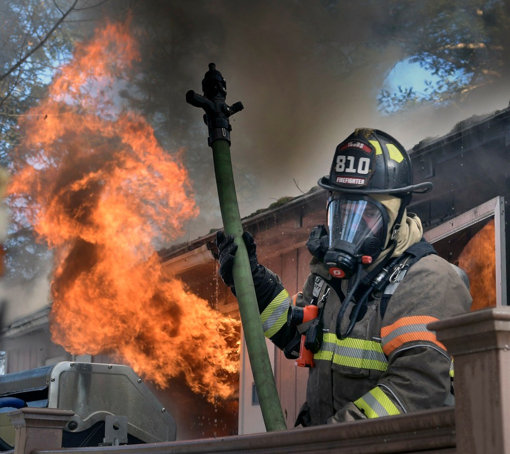 A firefighter rolls off the deck of a home that burned Tuesday on Keith Drive in Chelsea. Firefighters from several departments went to the blaze, which destroyed the residence, according to firefighters, but no injuries were reported.